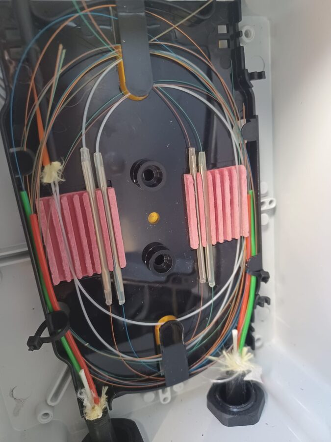 Optic-fibre splice tray with terminated and coiled fibre