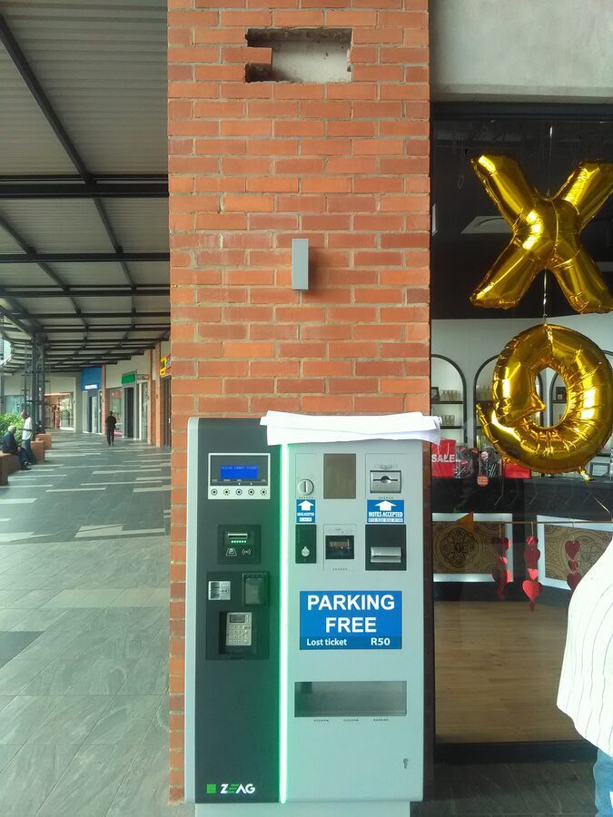 Parking pay station and safety mirror at a mall entrance